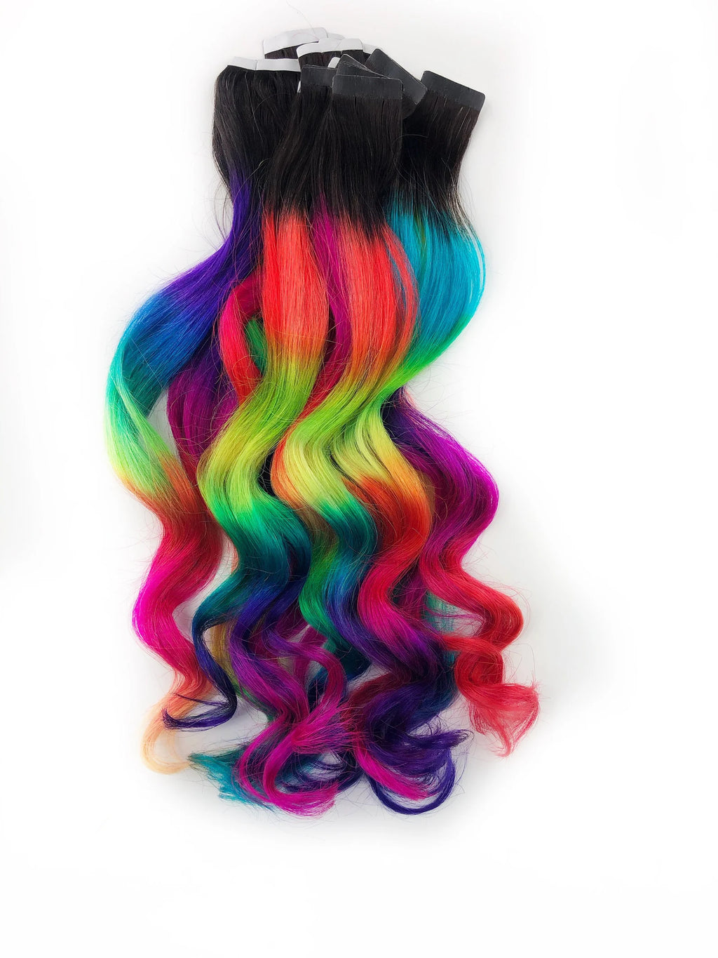 Curly clip-in human hair extensions, black roots fading into vivid neon rainbow ombre waves.
